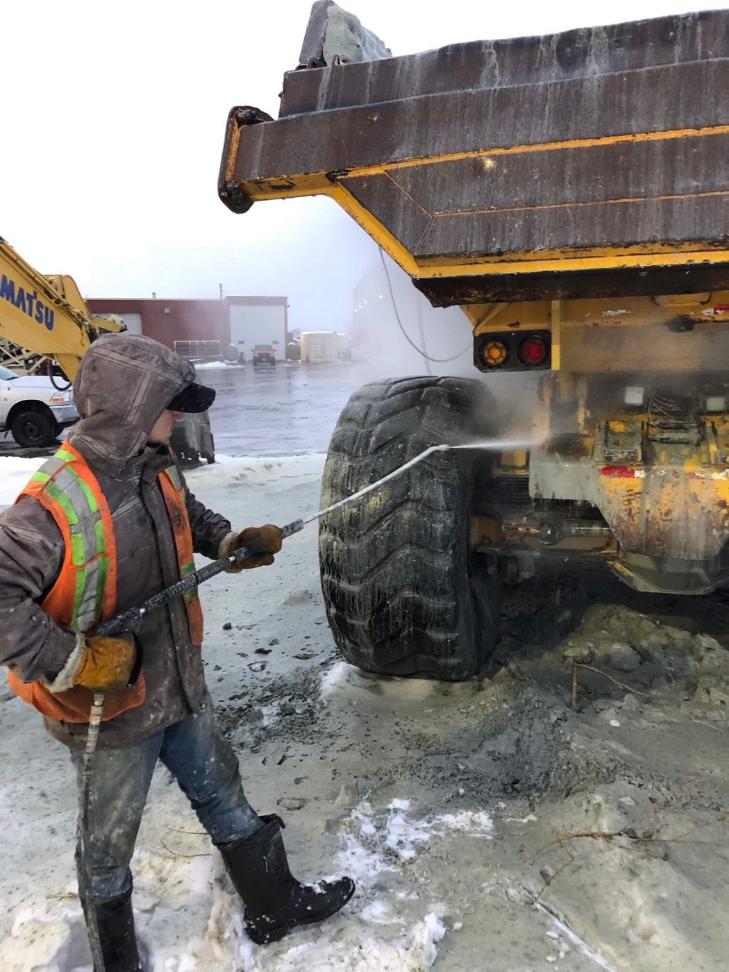 Packed mud being blasted out of a loader tire tread